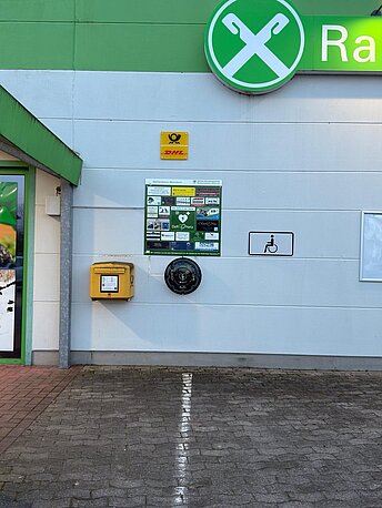 Öffentlicher AED im runden, beleuchteten Wandkasten rechst neben dem Eingang