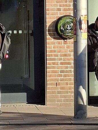 Außen neben Bäckerei Knaack
Rechts neben glastür TH 2B