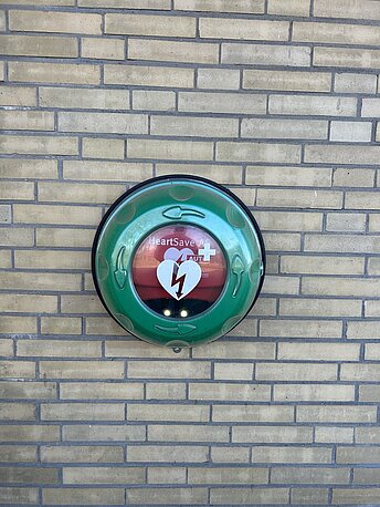 Öffentlicher AED im runden, grünen Wandkasten Öffentlicher AED im runden, grünen Wandkasten