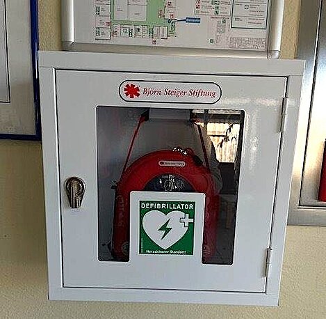 AED rechts im Eingangsbereich im weißen Wandkasten AED rechts im Eingangsbereich im weißen Wandkasten