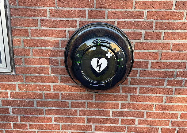AED Gerät im beleuchteten und alarmgesicherten Außenkasten an der Hauswand AED Gerät im beleuchteten und alarmgesicherten Außenkasten an der Hauswand