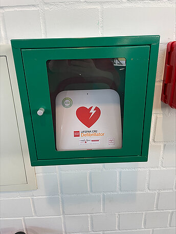 AED im grünen Wandkasten AED im grünen Wandkasten