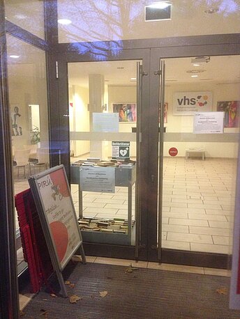 Haupteingang VHS REGION Lüneburg mit Hinweisschild AED