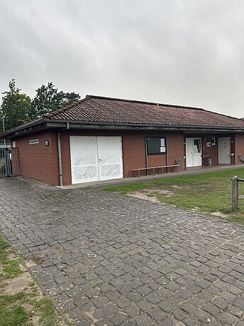 AED im weißen Wandkasten, Umkleidegebäude zwischen den Sportplätzen