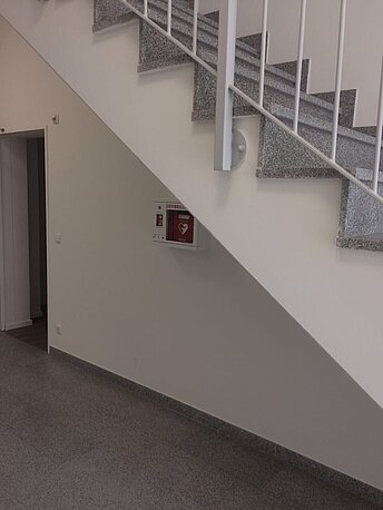 AED befindet sich hinter der Treppe im EG