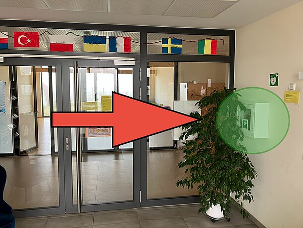 AED im weißen Wandkasten im Vorflur rechts an der Wand