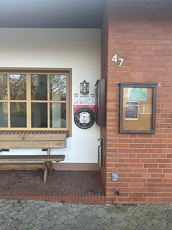 AED im runden beleuchteten Wandkasten rechts neben dem Fenster am Eingang