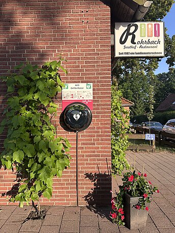 Öffentlicher AED im runden, beleuchteten Wandkasten. Schwarze Kappe drehen und abnehmen. Öffentlicher AED im runden, beleuchteten Wandkasten. Schwarze Kappe drehen und abnehmen.