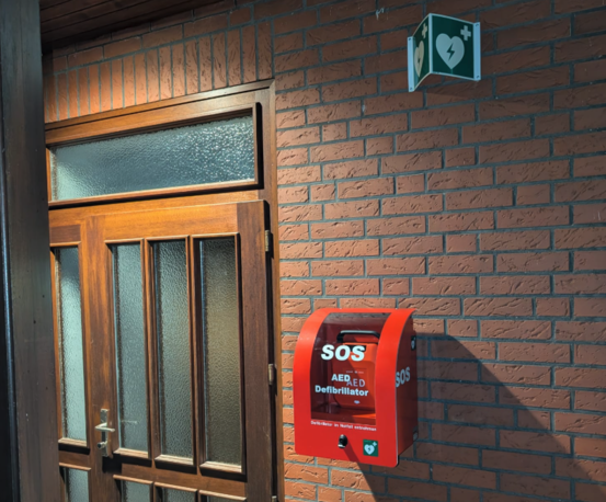 Hintere Gebäudeseite (Richtung Sporthalle), rechts neben der Eingangstür zum Feuerwehrhaus im roten Wandkasten