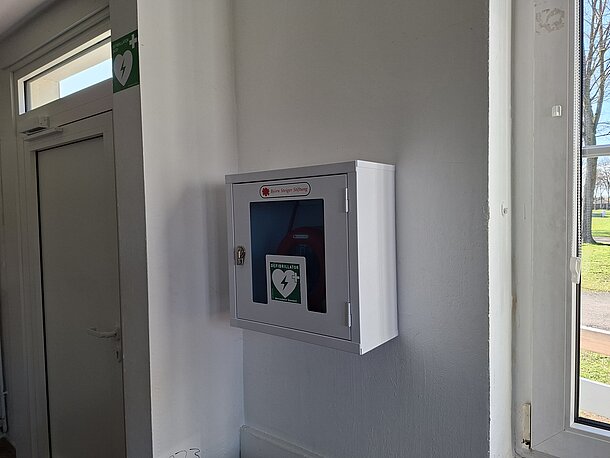 AED im weißen Wandkasten direkt links hinter der Eingangstür zum Jugendhaus/Jugendcafe