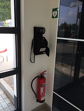 AED im Windfang links an der Wand 