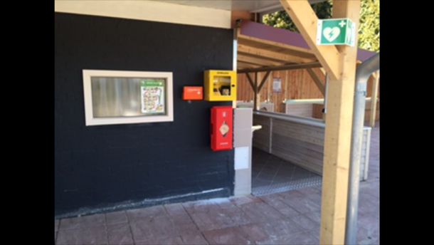 AED hängt beim Duscheingang der Herren