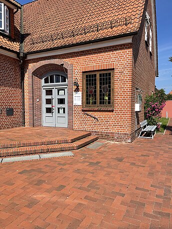 AED befindet sich an der Hauswand, rechts neben der Treppe 