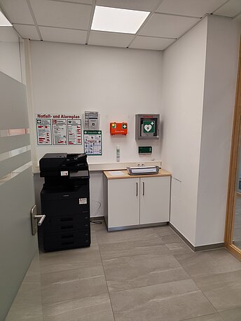 AED im grünen Wandkasten rechts neben dem Kopierer
