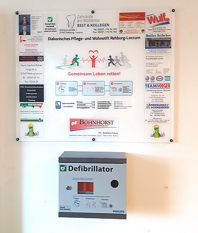 AED im weißen Wandkasten mit Informationsschild AED im weißen Wandkasten mit Informationsschild