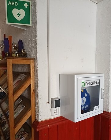 AED in der Ecke über der roten Vertäfelung