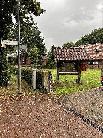 Einfahrt auf das Gelände des Heimathauses Wechold. AED an der Infotafel links