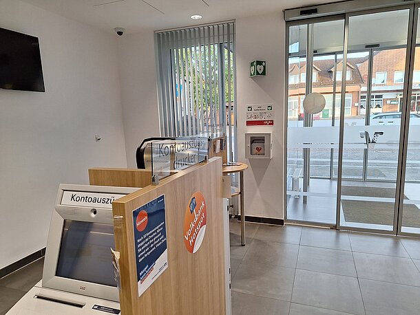 AED im Wandkasten direkt rechts hinter der zweiten Glastür