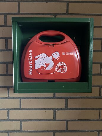 AED im grünen Wandregal