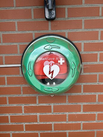Öffentlicher AED im runden, grünen Wandkasten Öffentlicher AED im runden, grünen Wandkasten