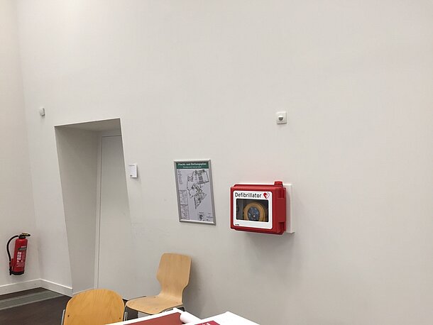 AED befindet gut sichtbar in der roten Wandhalterung
