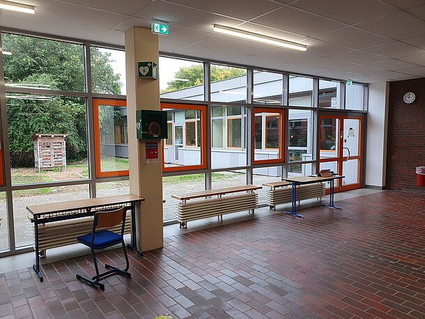 Eingangshalle, AED im wandmontierten Kasten an der Säule Fenster zum Innenhof Eingangshalle, AED im wandmontierten Kasten an der Säule Fenster zum Innenhof