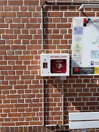 AED befindet sich an der Hauswand 