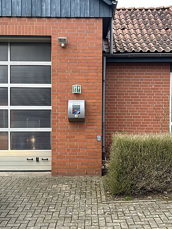 Öffentlicher AED rechts neben den Toren zur Fahrzeughalle