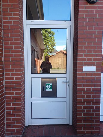 AED im silbernen Kasten direkt an der Tür zum Feuerwehr-Gerätehaus AED im silbernen Kasten direkt an der Tür zum Feuerwehr-Gerätehaus