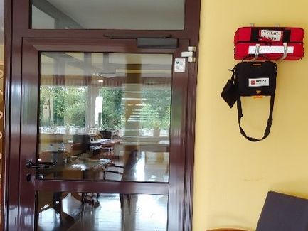 AED hinter der Glastür links an der Garderobenleiste AED hinter der Glastür links an der Garderobenleiste
